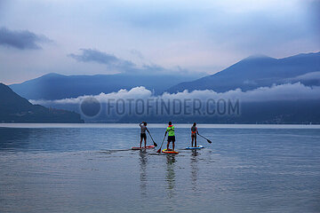 Schweiz  Ascona - Standup-Paddler auf dem Lago Maggiore in der Morgendaemmerung