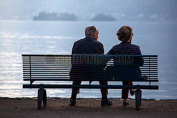 Schweiz  Ascona - Rentnerpaar auf Sitzbank am am Lago Maggiore