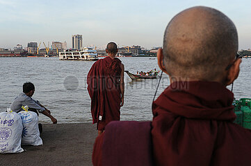 Yangon  Myanmar  Buddhistische Moenche warten am suedlichen Ufer des Yangon River auf Faehren und Flusstaxis