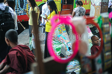 Yangon  Myanmar  Alltaegliche Strassenszene mit Muslimin und buddhistischem Moench in Spiegeln reflektiert