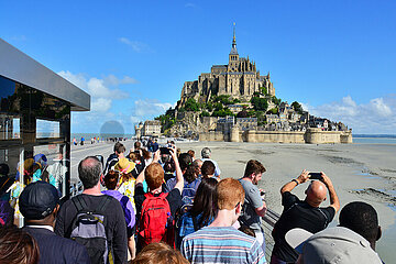 France. Manche (50). Mont Saint-Michel. Tourists taking photo of the Mont Saint-Michel from the bus stop which do the transfert from the parking lots to the site.