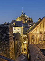France. Normandy. Manche (50) Mont Saint Michel - The village: Between two houses bordering the southern walkway  a small staircase leading to the main street. In the background  the abbey dwellings and the church tower.