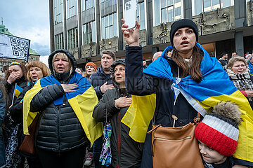 Deutschland  Bremen - Jahrestag des russischen Angriffkriegs gegen die Ukraine  ukrainische Fluechtlinge und Teilnehmer der Demonstration WE STAND WITH UKRAINE singen ihre Nationalhymne