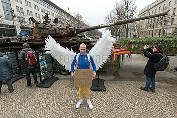 Berlin  Deutschland  DEU - Demonstrant mit Engelsfluegeln protestiert vor einem zerstoertemn russischen T-72B Panzer