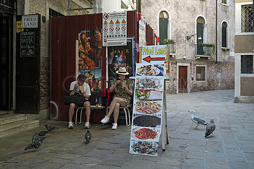 Venedig  Venetien  Italien  ITA - Asiatische Touristen sitzen in einer Gasse und essen Steetfood