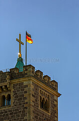 Deutschland  Eisenach - Turmkreuz (vergoldetes Kreuz von 1858) und deutsche Fahne auf dem Hauptturm der Wartburg (UNESCO-Welterbe)