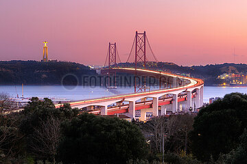 Portugal  Lisbon. View of the 25th of April Bridge  the Tagus and Christ the King in the background  at sunset