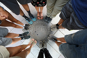 Batumi  Adscharien  Detailaufnahme: Menschen stehen im Kreis zusammen auf einem Gullideckel