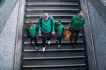 Berlin  Deutschland  Familie traegt gruene Kleidung zur Feier des St. Patrick's Day und geht Treppe zur U-Bahn runter