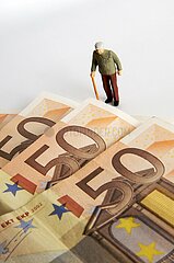 France. Elderly man  figurine  and euro notes. The cost of retirement