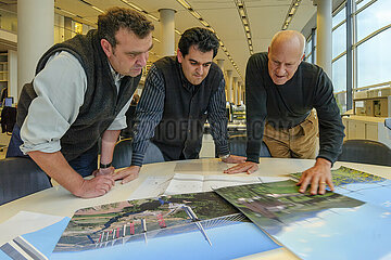ARCHIVES AUGUST 2001 - ENGLAND. LONDON. BATTERSEA DISTRICT. SIR LORD NORMAN FOSTER AND HIS PROJECT DIRECTORS ALISTAIR LENCZNER AND MOUZHAN MAJIDI STUDY AND COMMENT ON PHOTOGRAPHS AND PLANS OF THE MILLAU VIADUCT