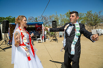 Tuerkei  Bogazkoey Sariyahsi - Polnisch-tuerkisches Brautpaar tanzt bei traditioneller Hochzeit auf dem Dorf in Anatolien  das Paar ist nach einem Brauch mit Geldscheinen dekoriert