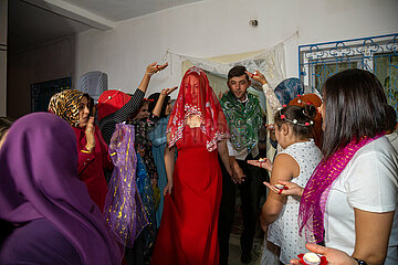 Tuerkei  Bogazkoey Sariyahsi - Hochzeit auf dem Dorf in Anatolien: Das polnisch-tuerkische Brautpaar tritt in traditioneller Kleidung aus dem Haus  wo es von Familie und Gaesten mit Kerzen begruesst wird