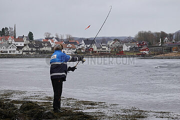 Vangshylla  Norwegen  Mann wirft am Ufer seine Angelrute aus