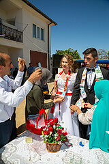 Tuerkei  Bogazkoey Sariyahsi - Polnisch-tuerkisches Brautpaar bei traditioneller Hochzeit auf dem Dorf in Anatolien  das Paar wird nach einem Brauch mit Geldscheinen dekoriert