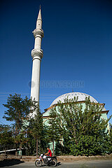 Tuerkei  Bogazkoey Sariyahsi - Moschee in einem Dorf in Anatolien  Junge auf Moped