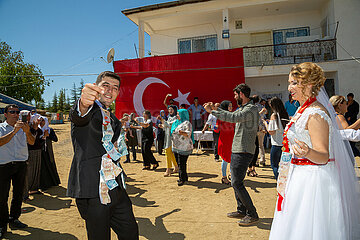 Tuerkei  Bogazkoey Sariyahsi - Polnisch-tuerkisches Brautpaar tanzt bei traditioneller Hochzeit auf dem Dorf in Anatolien  das Paar ist nach einem Brauch mit Geldscheinen dekoriert