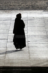 Doha  Katar  Frau traegt einen traditionellen schwarzen Umhang