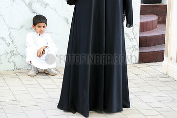 Doha  Katar  kleiner Junge sitzt grimmig vor seiner Mutter am Boden