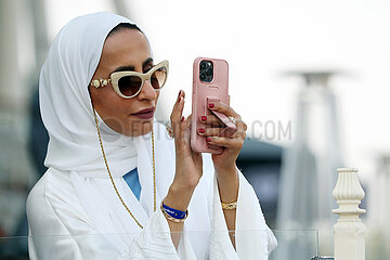 Doha  Katar  Frau macht ein Foto mit ihrem Smartphone