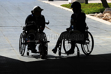 Doha  Silhouette: Rollstuhlfahrerinnen unterhalten sich