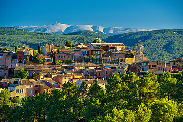 FRANCE. PROVENCE. VAUCLUSE (84) LUBERON REGIONAL NATURAL PARK. THE VILLAGE OF ROUSSILLON LABELED AS ONE OF THE MOST BEAUTIFUL VILLAGES IN FRANCE  WITH MONT VENTOUX MOUNTAIN IN THE BACKGROUND