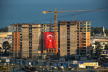 Tuerkei  Antalya - Baustelle eines Hochhauses mit riesiger tuerkischer Flagge an der Fadssade  hinten das Mittelmeer