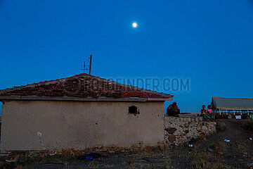 Tuerkei  Bogazkoey Sariyahsi - Roma  Vater mit Kindern  sitzen am Abend auf einer Mauer