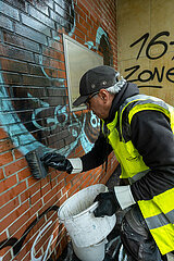 Deutschland  Bremen - Spezialfirma entfernt unliebsame Graffiti an einer Hauswand