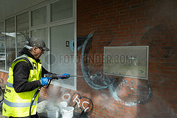 Deutschland  Bremen - Spezialfirma entfernt unliebsame Graffiti an einer Hauswand mit Hochdruckreiniger (HDR)  Wasser mit chemischen Zusatz