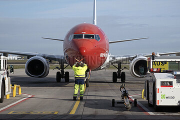 Schoenefeld  Deutschland  Boden-Lotse weist ein Flugzeug der Norwegian Airlines auf dem Vorfeld des Flughafen BER in die Parkposition ein