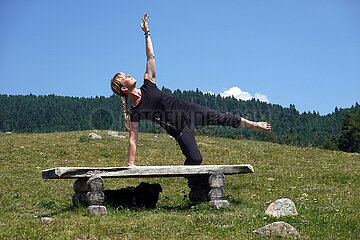 Ritten  Italien  Frau auf einer Bank beim Yoga in der Natur