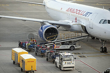 Istanbul  Tuerkei  Kofferwagen vor einem Flugzeug der Anadolujet auf dem Vorfeld des Flughafen Istanbul-Sabiha Goekcen