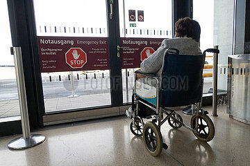 Schoenefeld  Deutschland  Rollstuhlfahrerin wartet vor einem Notausgang im Terminal des BER