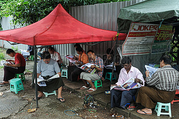 Yangon  Myanmar  Einheimische lesen an einem Zeitungsstand am Strassenrand Zeitung