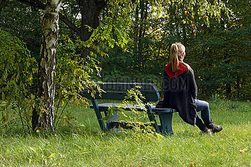 Seewalde  Deutschland  Frau sitzt allein auf einer Parkbank