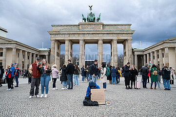 Berlin  Deutschland  Ein Wohnungsloser bettelt mit einem Schild vor dem Brandenburger Tor