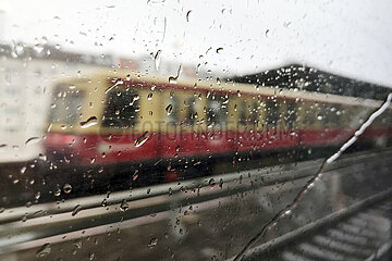 Berlin  Deutschland  S-Bahn zeichnet sich schemenhaft hinter einem mit Regentropfen bedecktem Fenster ab