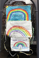 Berlin  Deutschland  Kinderzeichnungen mit Regenboegen haengen an einer Haustuer