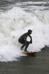 Binz  Deutschland  Mann surft auf der stuermischen Ostsee