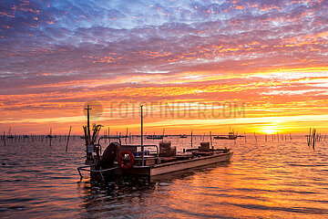 FRANCE. GIRONDE (33) ARCACHON BASIN. SUNSET WITH FLAT-BOTTOMED OYSTER FARMERS BOATS IN THE FOREGROUND