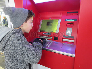 Junge an einem EC-Automaten