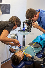 Kieferchirurg macht Fotos von Patienten um zu visualisieren wie Zahnklammer später aussieht