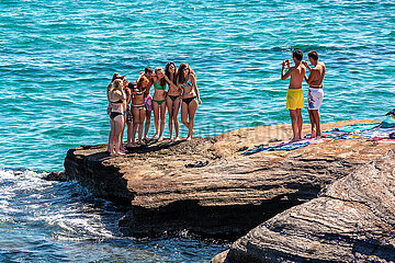 FRANCE. HERAULT (34) CAP D'AGDE. YOUNG PEOPLE TAKE PICTURES OF THEMSELVES ON THE CLIFFS