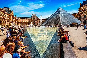 FRANCE. PARIS (75) 1ST DISTRICT. TOURISTS REFRESHING IN A BASIN IN THE COUR NAPOLEON FACING THE LOUVRE MUSEUM AND THE PYRAMID DESIGNED BY ARCHITECT IEOH MING PEI