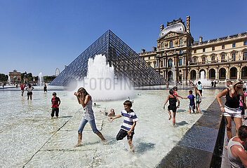 FRANCE. PARIS (75) 1ST DISTRICT. CHILDREN REFRESHING IN A BASIN OF THE COUR NAPOLEON FACING THE PYRAMID AND THE LOUVRE MUSEUM