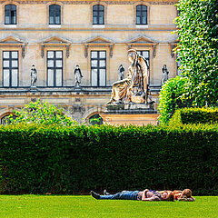 FRANCE. PARIS (75) THE LOUVRE MUSEUM. CAROUSEL GARDENS. A COUPLE LYING ON A LAWN