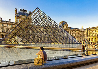 FRANCE. PARIS (75) 1ST DISTRICT. AT SUNSET  A COUPLE KISS IN FRONT OF THE LOUVRE PYRAMID DESIGNED BY ARCHITECT IEOH MING PEI  WITH THE SULLY PAVILION OF THE LOUVRE MUSEUM IN THE BACKGROUND