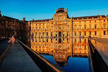 FRANCE.PARIS (75) 1ST DISTRICT. THE LOUVRE MUSEUM REFLECTED IN A BASIN OF THE COUR NAPOLEON AT SUNSET