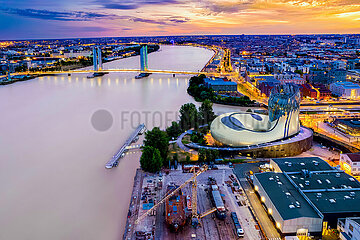FRANCE. GIRONDE (33) BORDEAUX. AERIAL VIEW OF THE CITE DU VIN  THE GARONNE RIVER AND THE ENTRANCE TO THE BASSINS A FLOAT  AT DUSK  WITH THE CHABAN DELMAS BRIDGE IN THE BACKGROUND